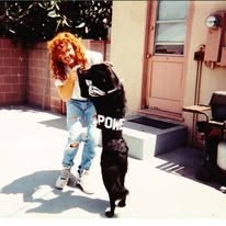 A band member in torn jeans and POWER-lettered pants, late 1980s