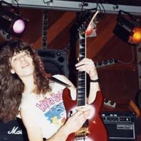 Guitarist with long dark curls and a red guitar, late 1980s