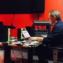 Band member working at the studio computer and keyboard